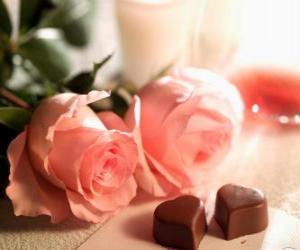 Rompicapo di Due rose rosa con due a forma di cuore cioccolatini