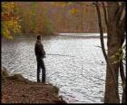 Pesca - Pescatore di fiume in azione in un paesaggio boscoso